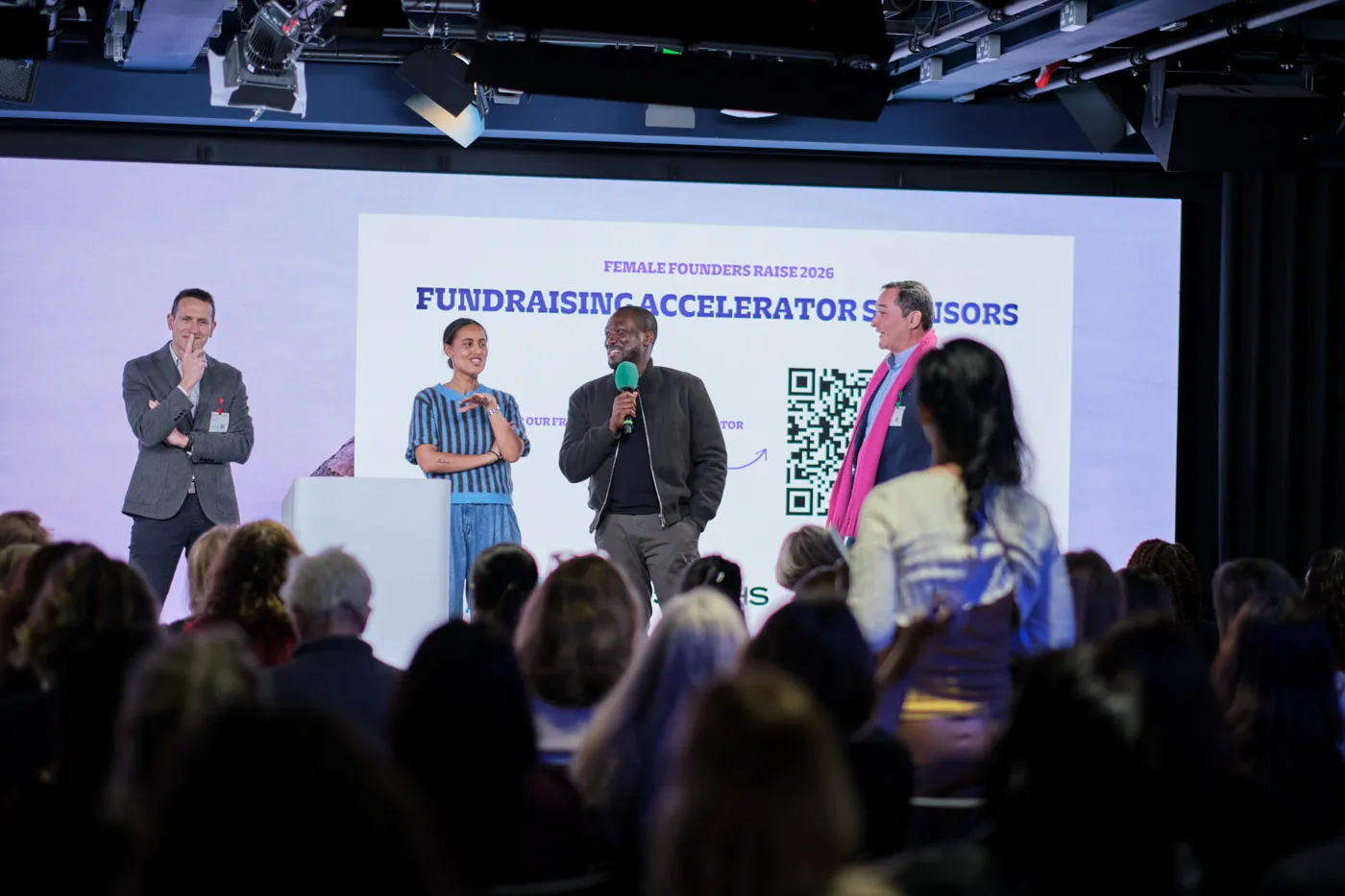 Speakers on stage at Female Founders Raise 2026 in front of the Fundraising Accelerator sponsors slide